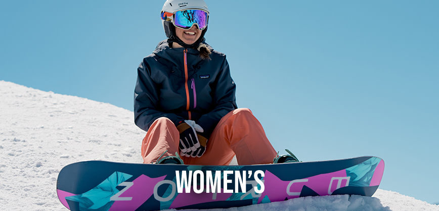 Shop women's new season. A woman inwith snowboard sitting on the side of a hill